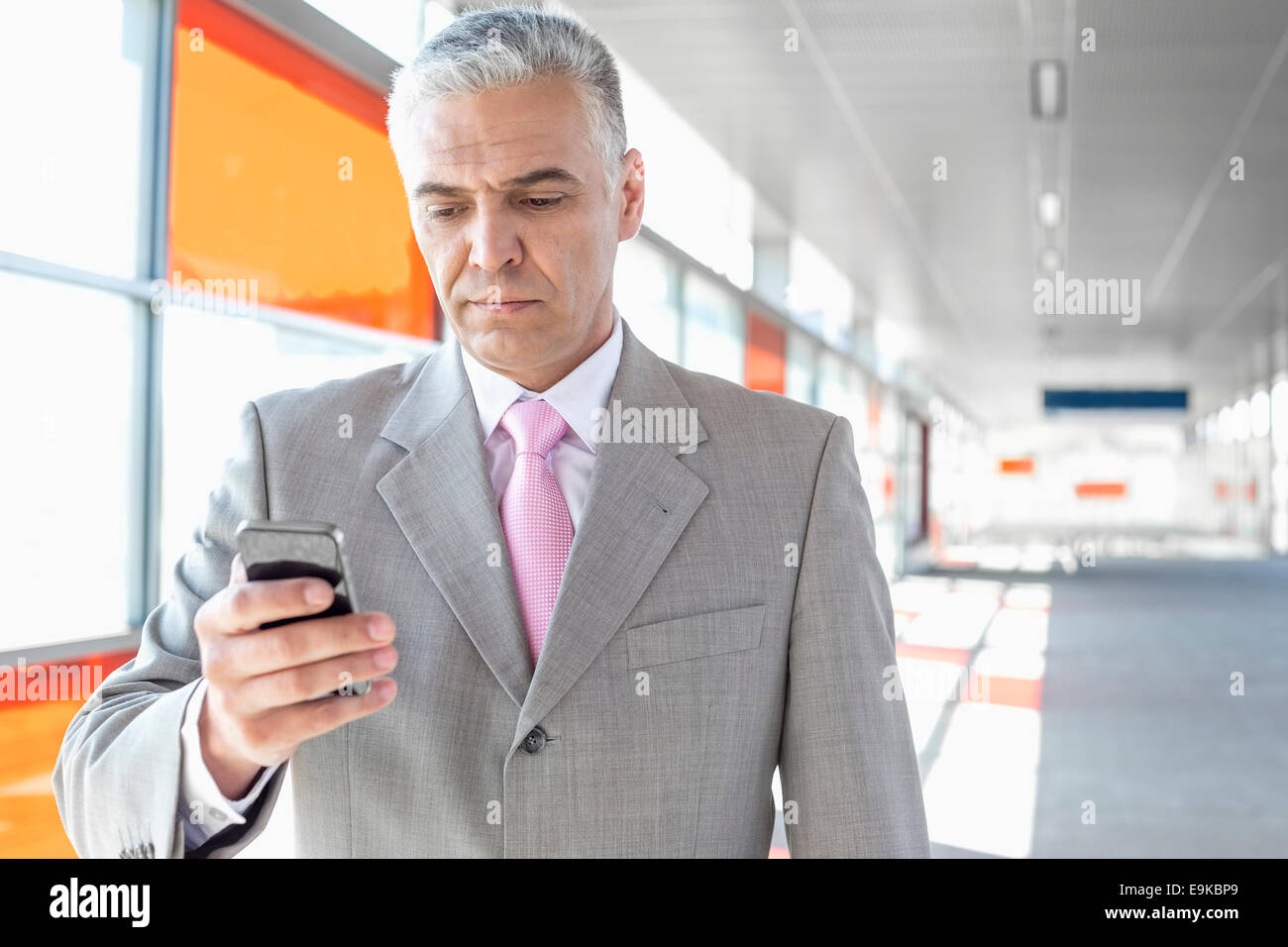 Middle aged businessman text messaging through cell phone at railroad station Stock Photo