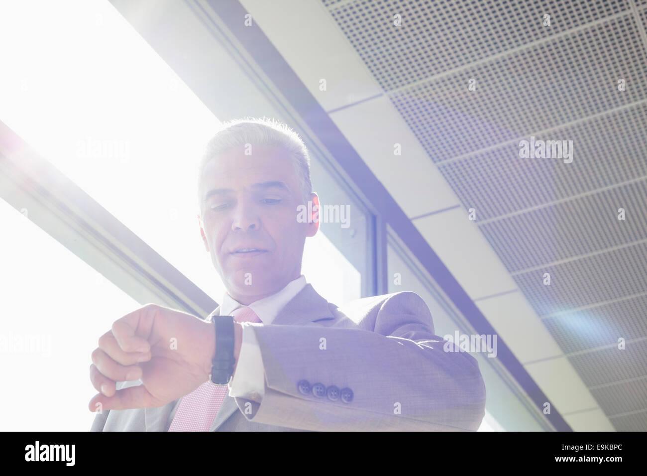 Middle aged businessman checking time at railroad station Stock Photo ...