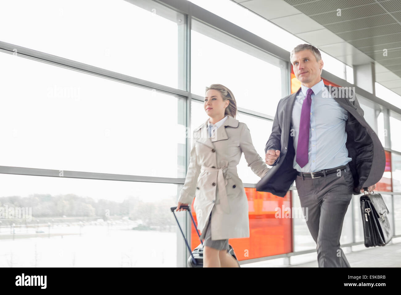 Businessman and businesswoman rushing in railroad station Stock Photo