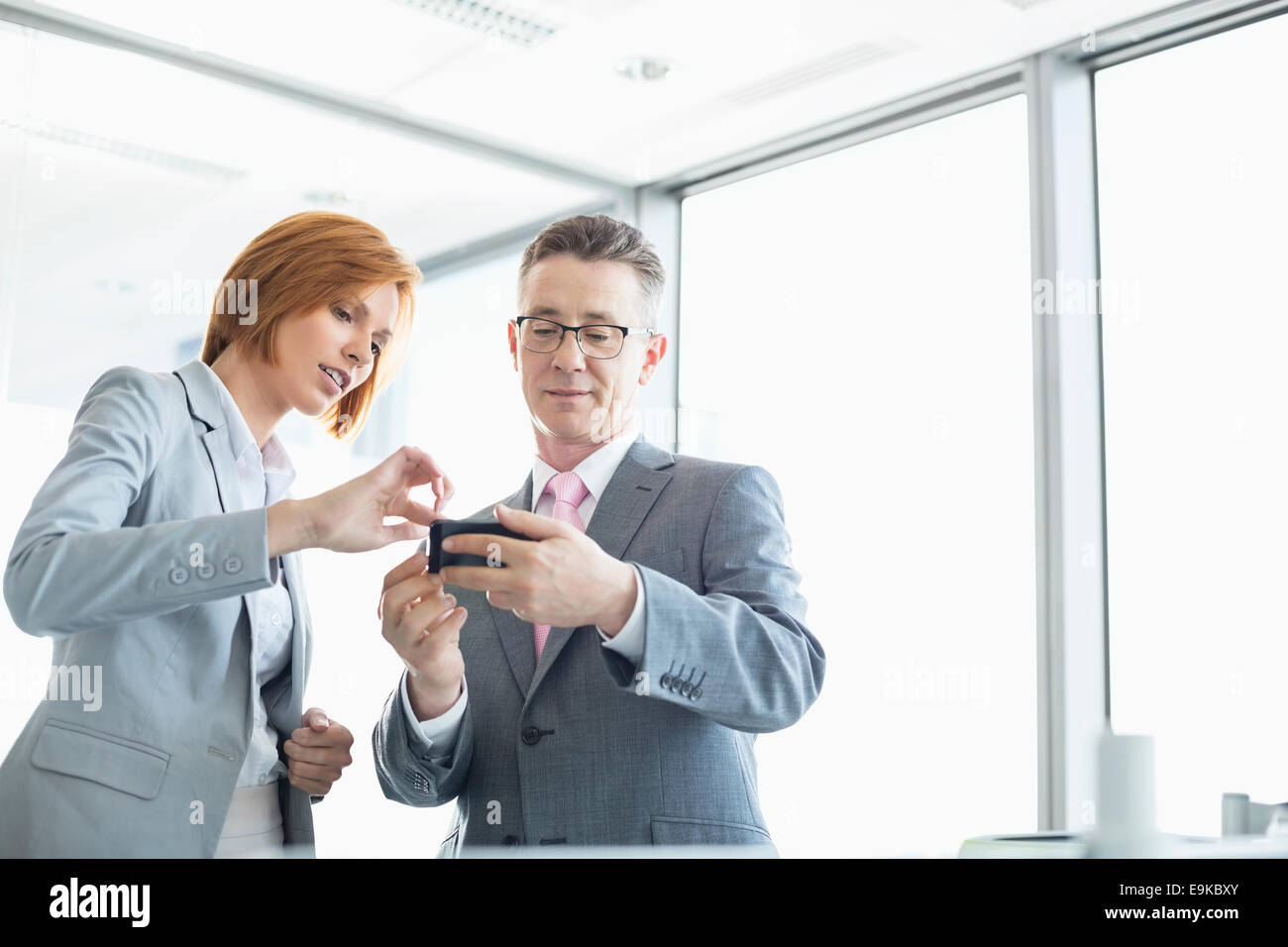 Businessman and businesswoman using cell people in office Stock Photo