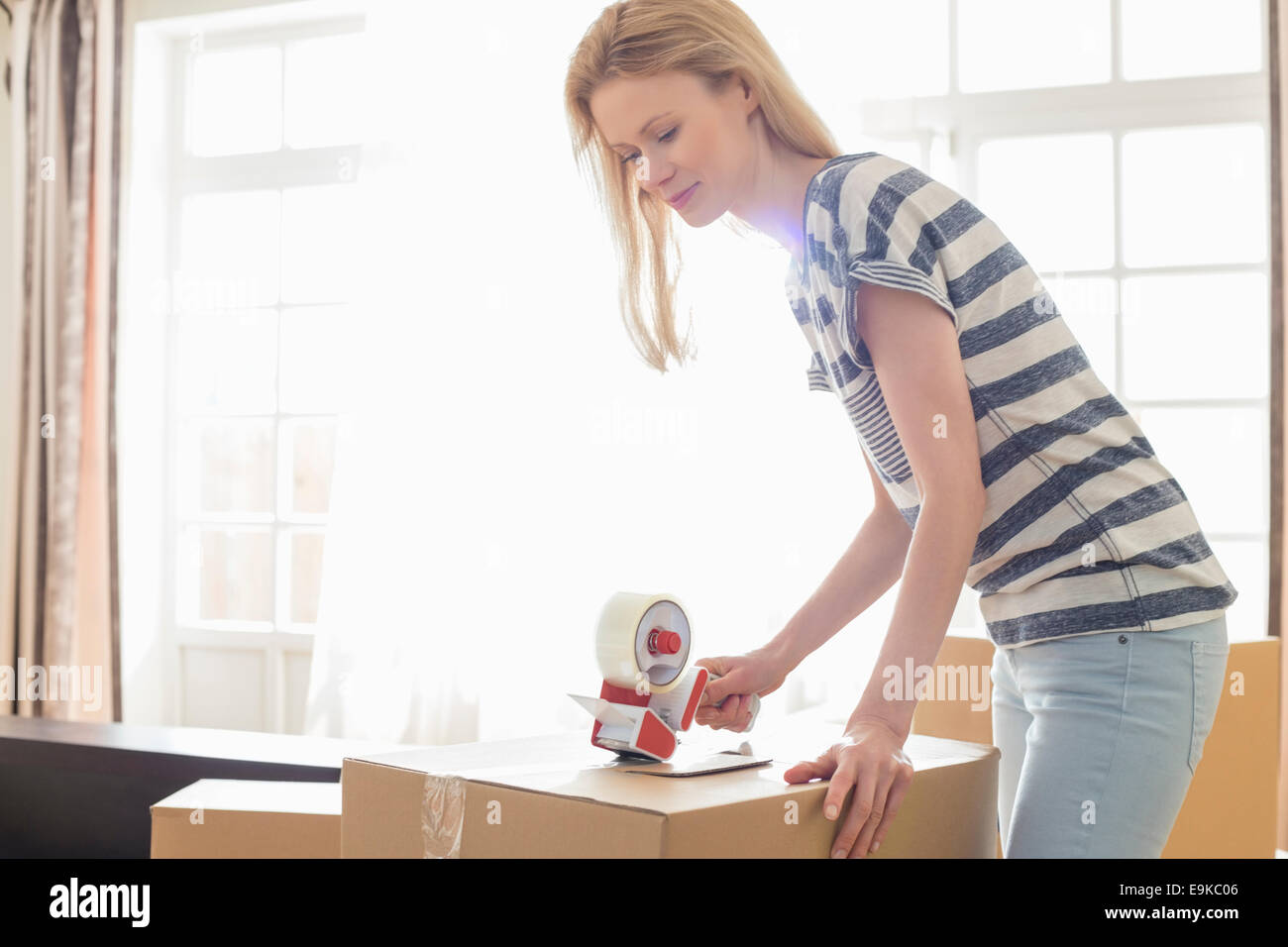 Woman packing moving box at home Stock Photo