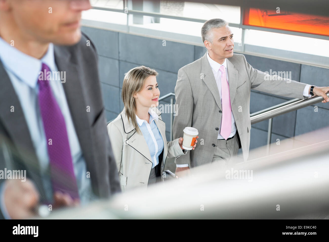 Businesspeople walking up stairs in train station Stock Photo