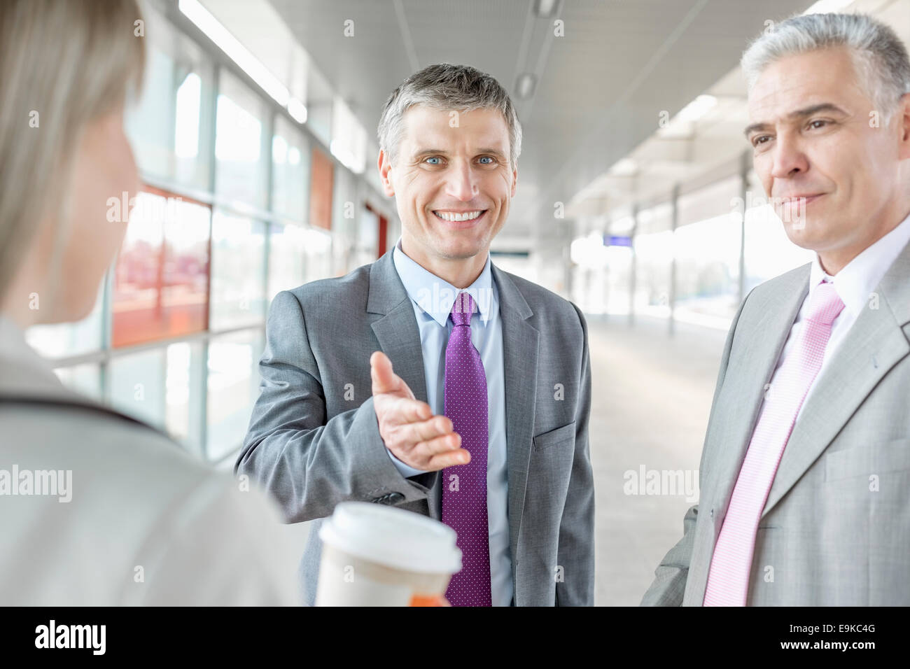 Businessman discussing with colleagues at railroad platform Stock Photo