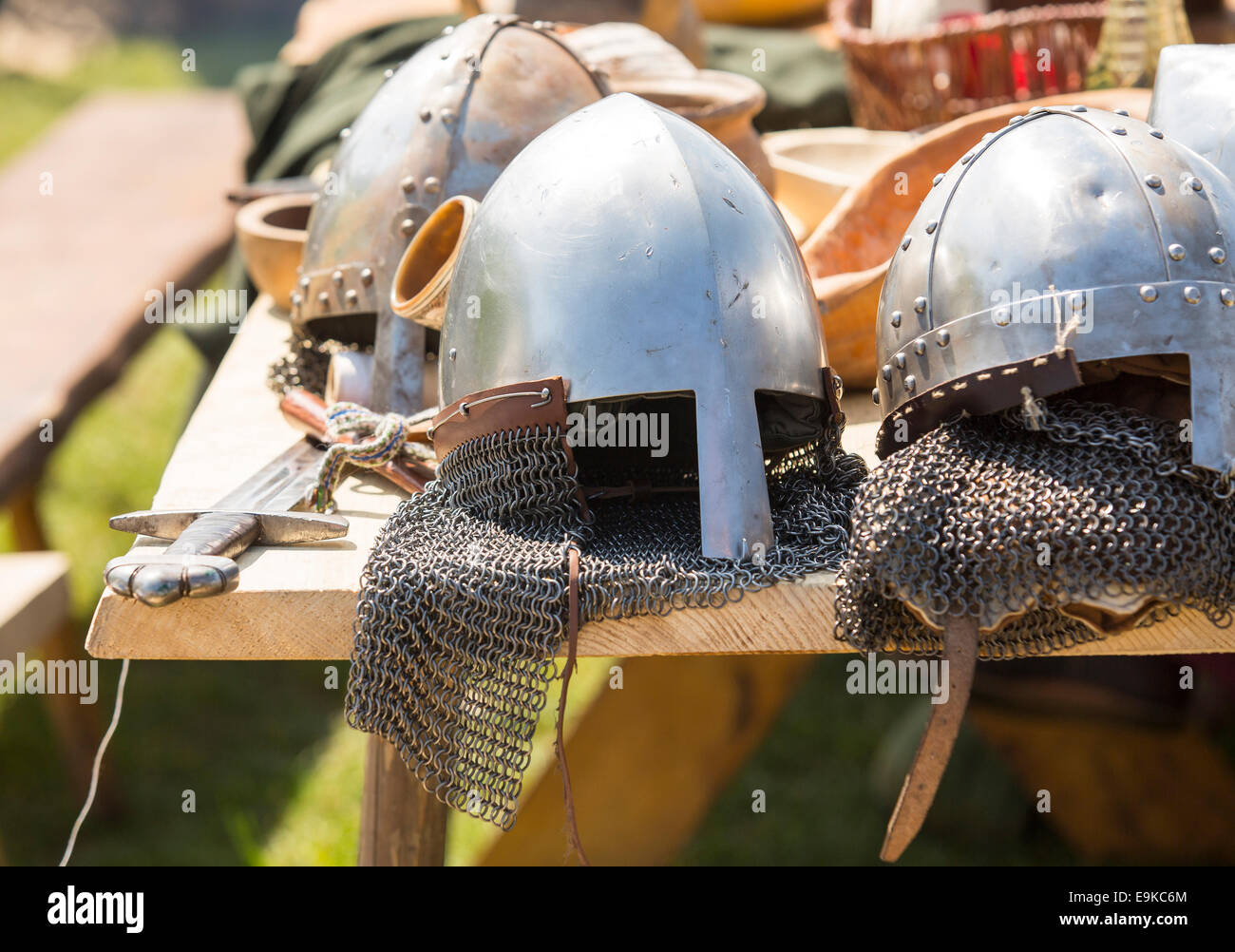 Medieval armor, helmets and swords lie on a wooden table outdoor Stock  Photo - Alamy