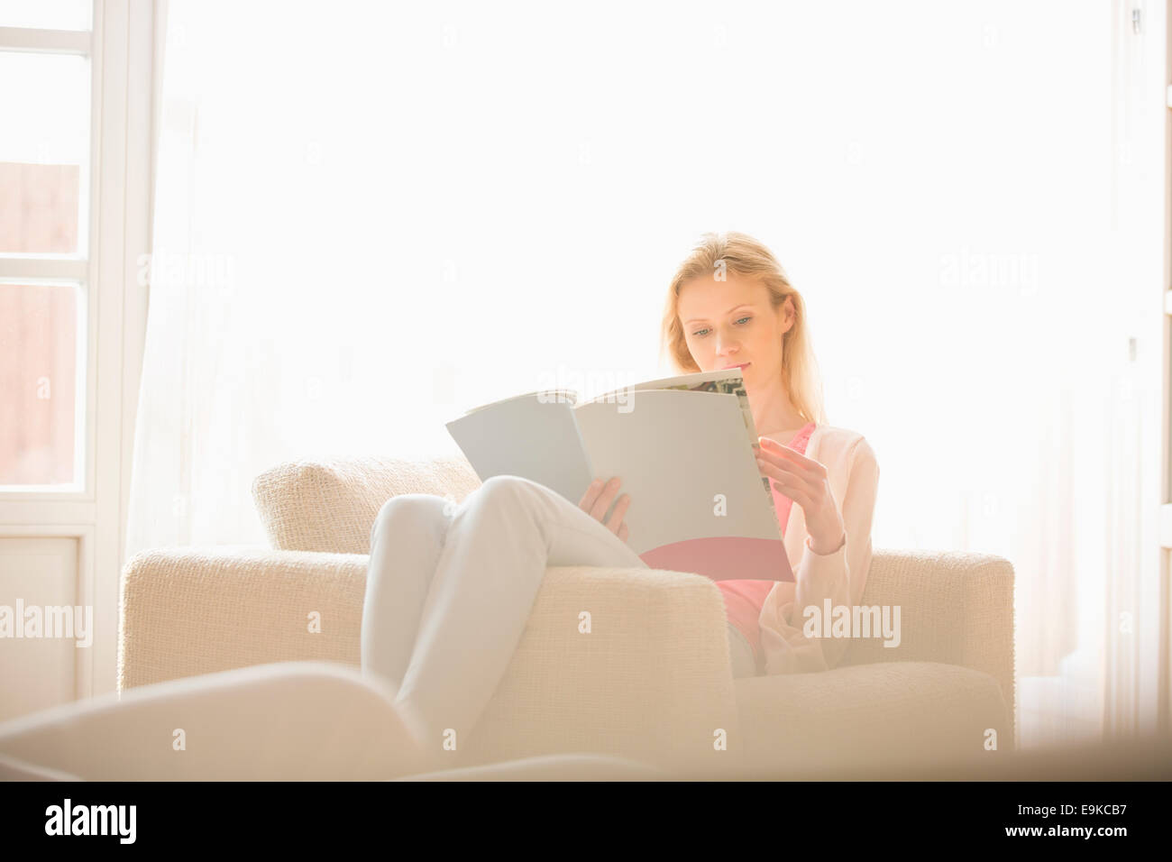 Beautiful woman reading magazine at home Stock Photo