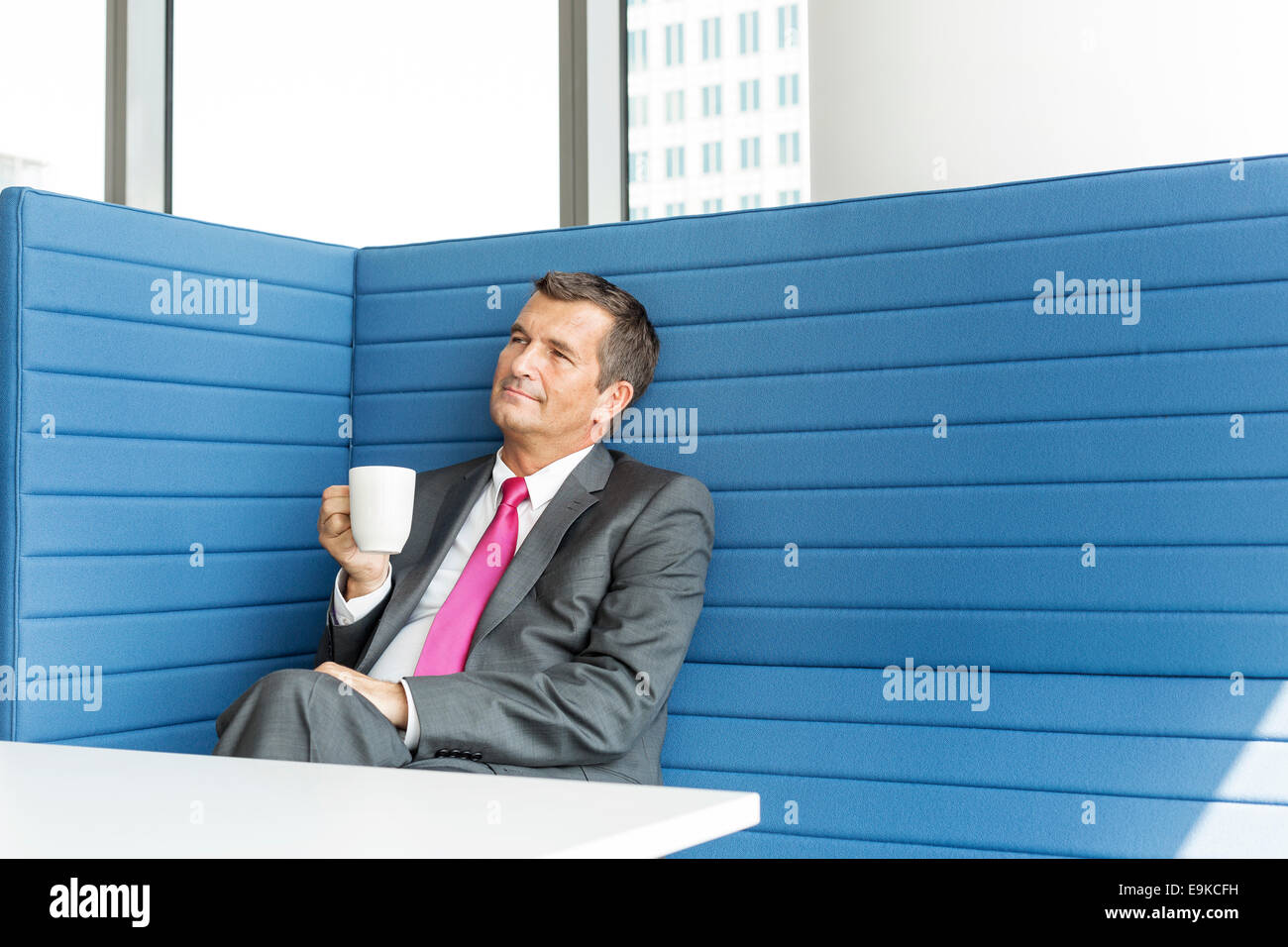 Mature businessman taking coffee break in office Stock Photo