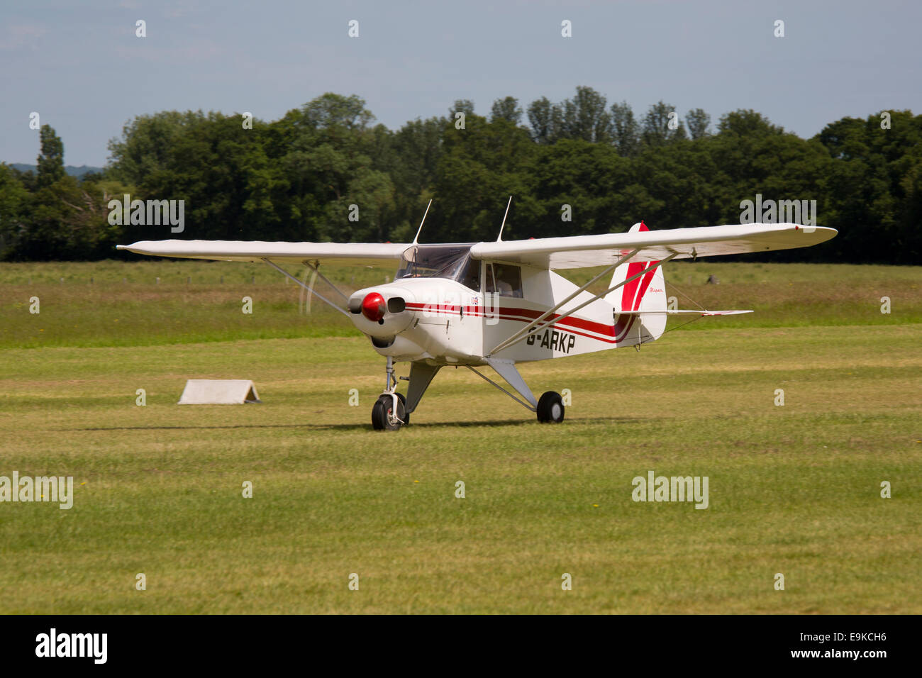 Piper PA-22-160 Colt G-ARKP taking off from grass runway at Headcorn Airfield Stock Photo
