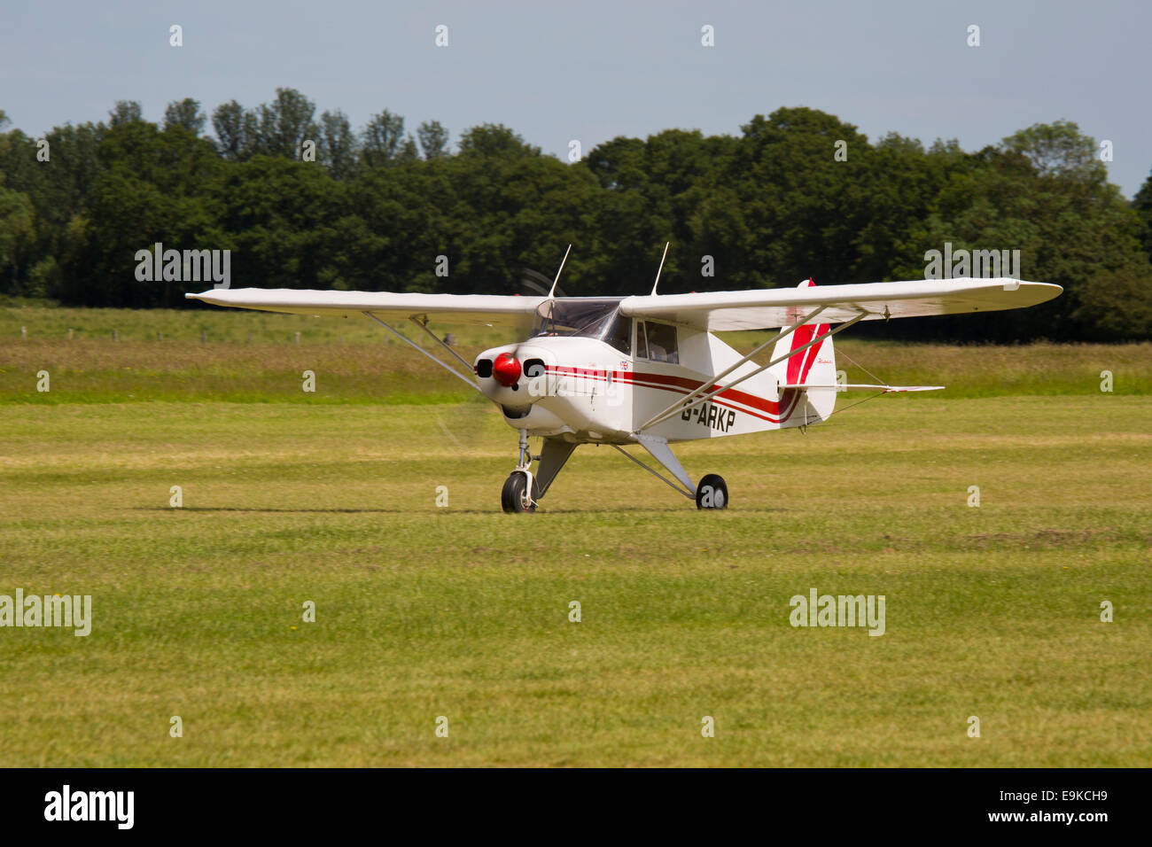 Piper PA-22-160 Colt G-ARKP taking-off from grass runway at Headcorn Airfield Stock Photo