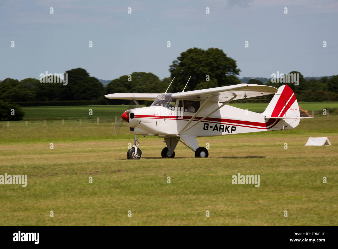 Piper PA-22-160 Colt G-ARKP taking off from grass runway at Headcorn Airfield Stock Photo