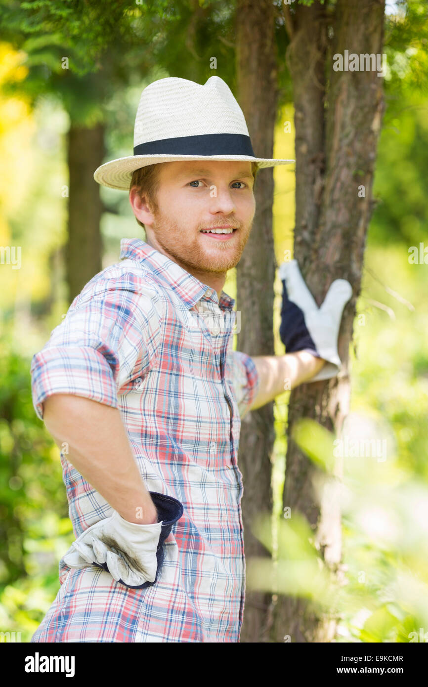 Portrait of confident gardener standing at plant nursery Stock Photo ...