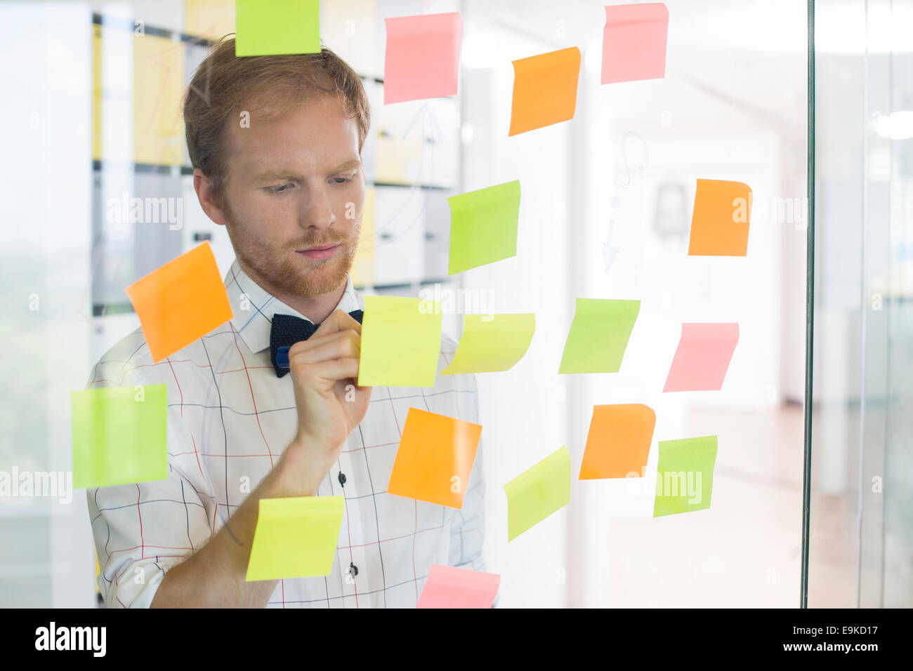 Creative businessman writing on sticky paper at office Stock Photo - Alamy