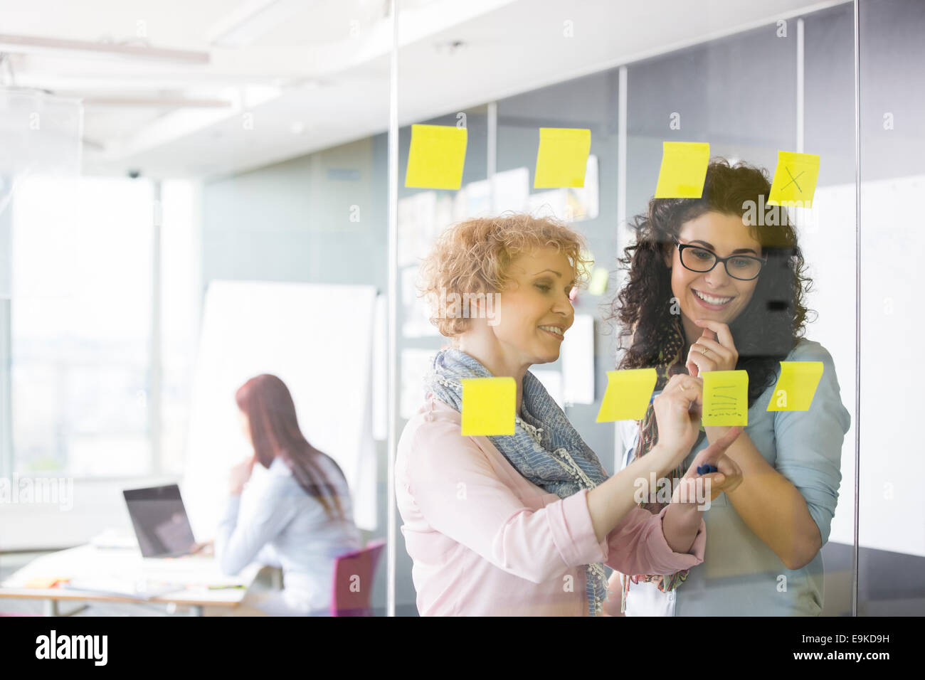 Business women brainstorming with sticky notes in office Stock Photo