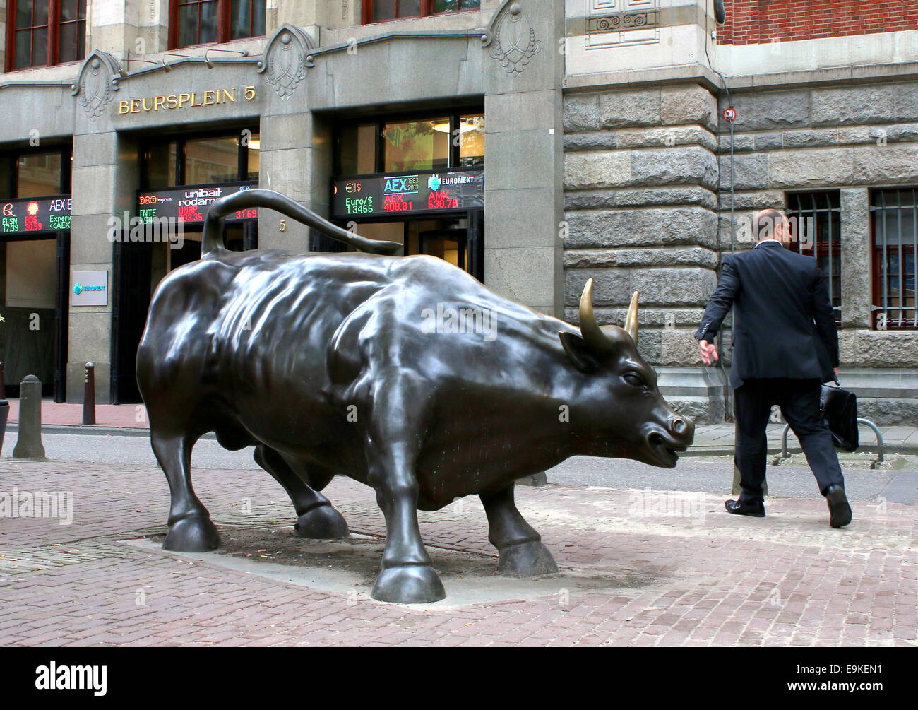Statue of a charging bull in front of the Amsterdam stock Exchange at Beursplein in the Dutch capital, trader going to work Stock Photo
