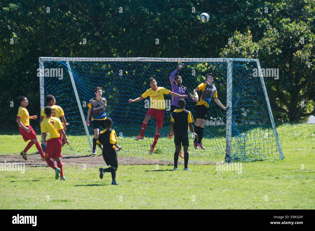 Youth football players defending a high ball in front of the goal, Cape