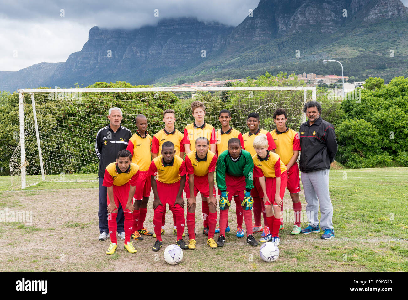 Youth football team (U15) with coaches poses in front of a goal Cape