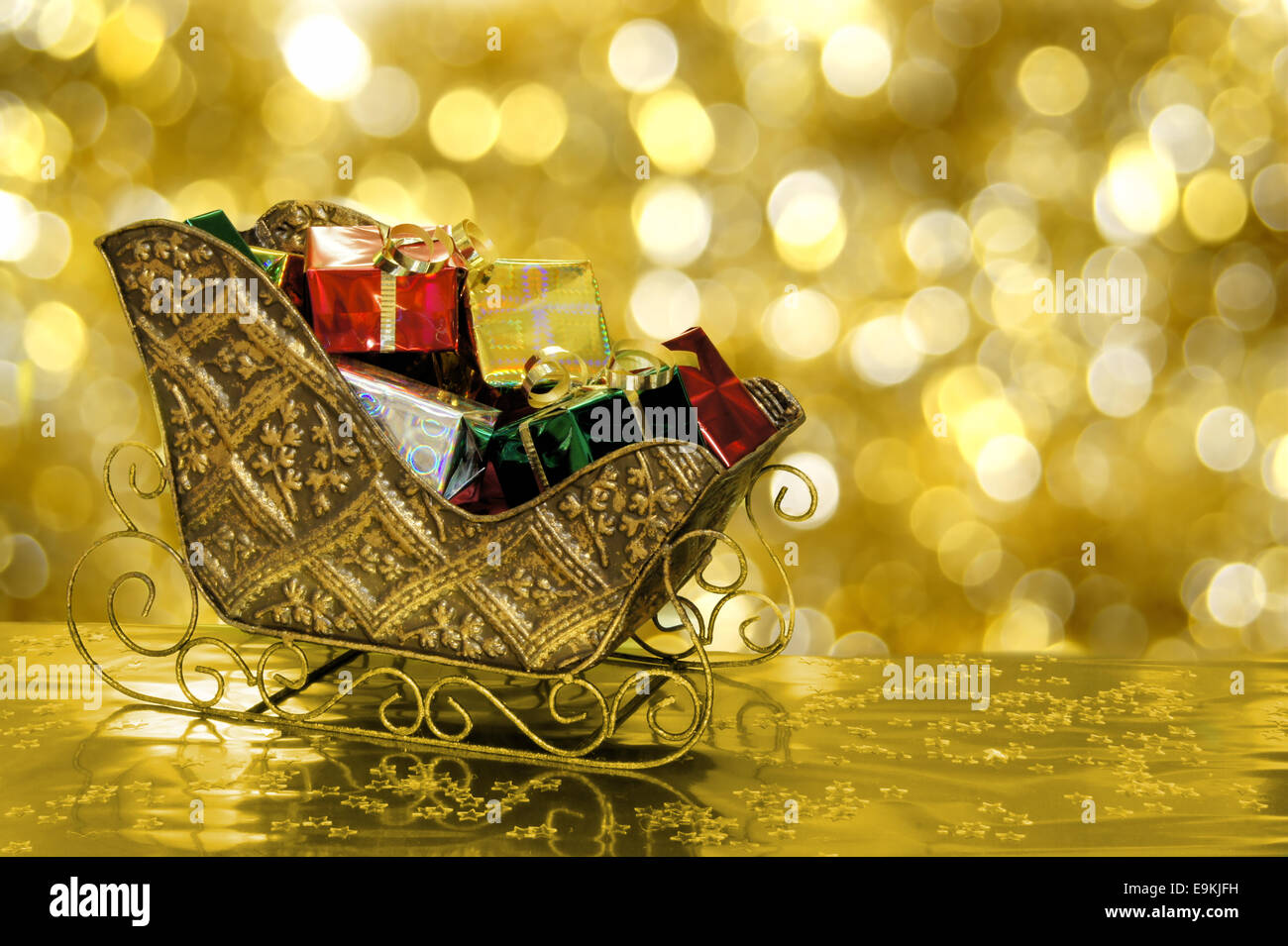 Christmas sleigh or sled filled with gift boxes with gold background ...
