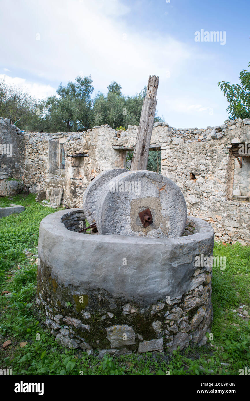Traditional olive press in the remains of a house at Zakynthos, Greece  (collapsed because of an eathquake) Stock Photo