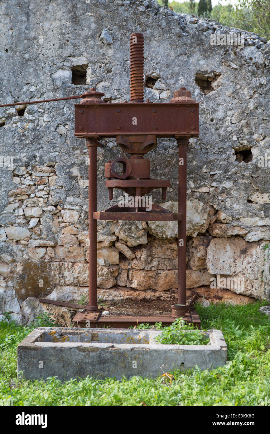 Traditional olive press in the remains of a house at Zakynthos, Greece  (collapsed because of an eathquake) Stock Photo