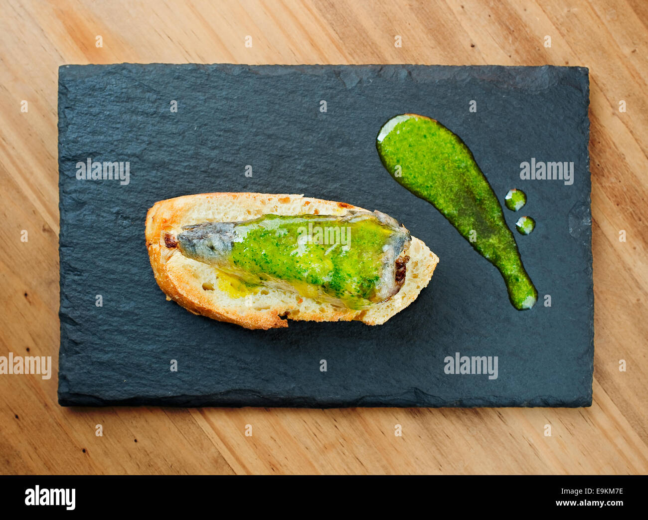 Typical spanish pincho de sardina in slate plate. (Sardine pintxo) Stock Photo