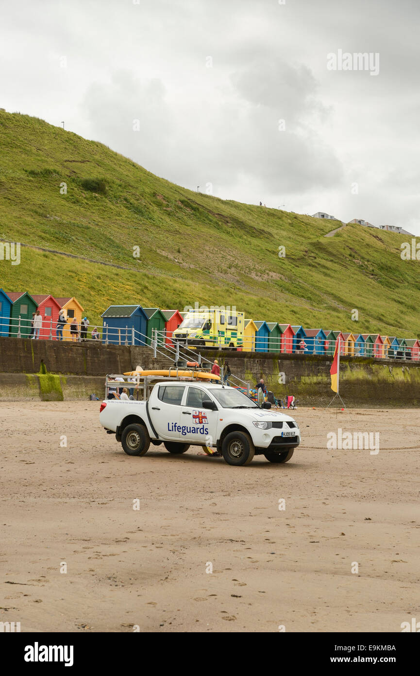 RNLI utility vehicle parked on Whitby beach, N Yorks, UK. An NHS ambulance is in the background. Stock Photo