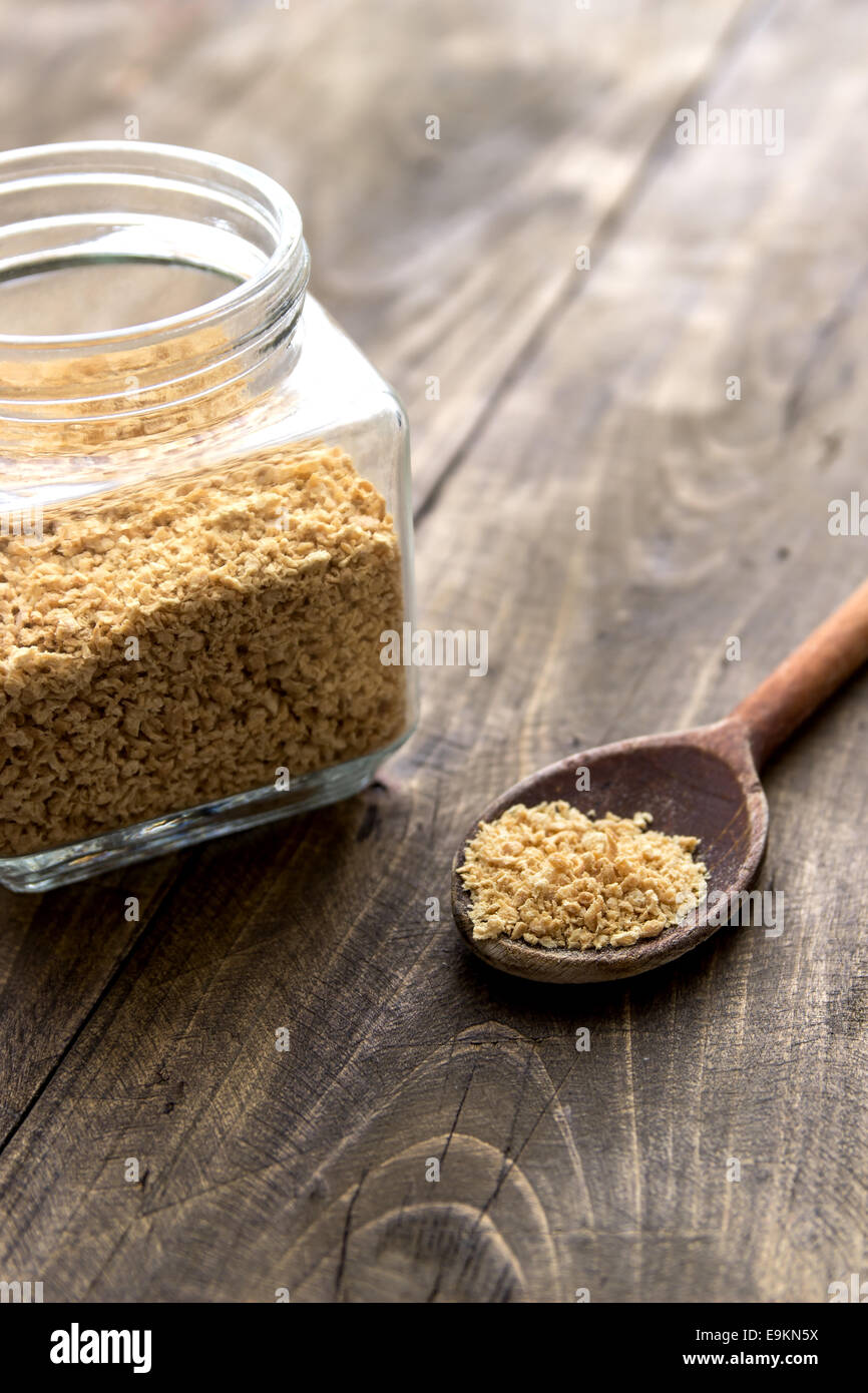 raw soy flakes in wooden spoon  over wooden background Stock Photo