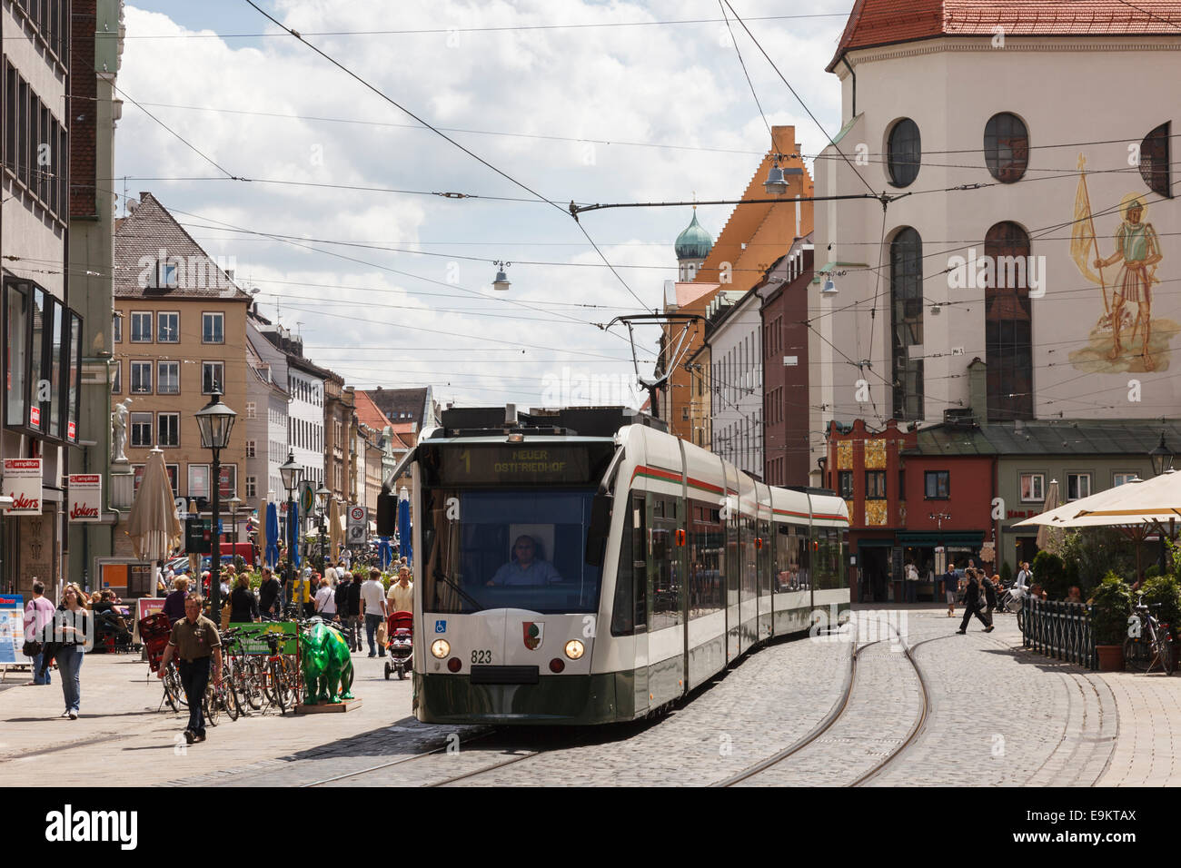 Tram on busy cobbled street in city centre by Moritzkirke church in Maximilianstrasse, Augsburg, Bavaria, Germany, Europe. Stock Photo