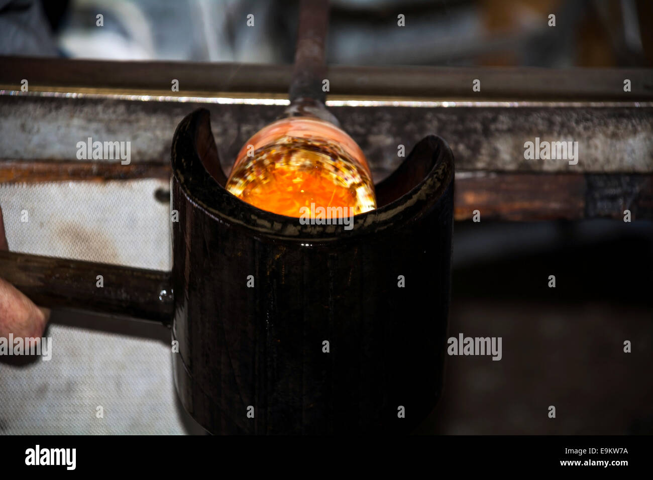 Shaping molten glass to a paperweight in production. Stock Photo