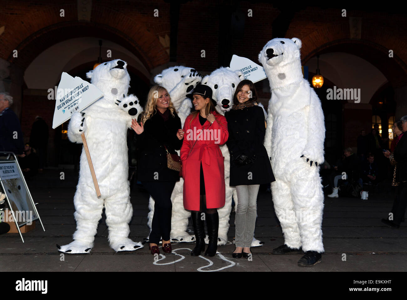 Copenhagen, Denmark. 29th October, 2014. Polar bears in the streets of Copenhagen – here pictured together with local Copenhageners. This happening was organized by World Wildlife Foundation (WWF) in order to point out that the global warming has serious consequences for the wildlife. The sign to the left says: “Can you imagine a world without us”?  WWF raise the issue because the UN climate panel meeting – also in Copenhagen – next Sunday shall publish it’s Summary Report with recommendation for actions to global leaders. Credit:  OJPHOTOS/Alamy Live News Stock Photo
