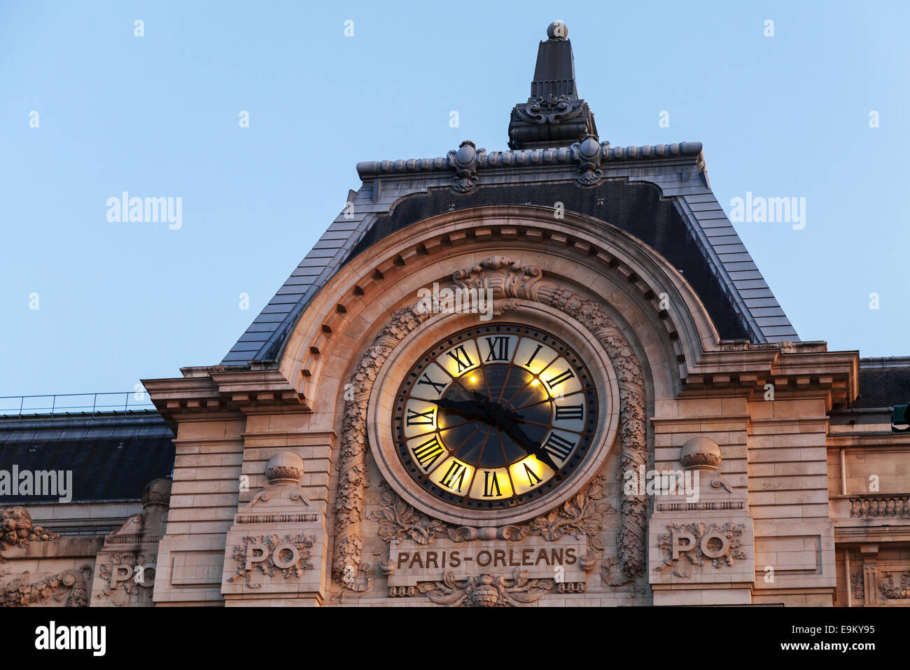 Evening illumination of famous ancient clock on the wall of Orsay Museum in Paris Stock Photo