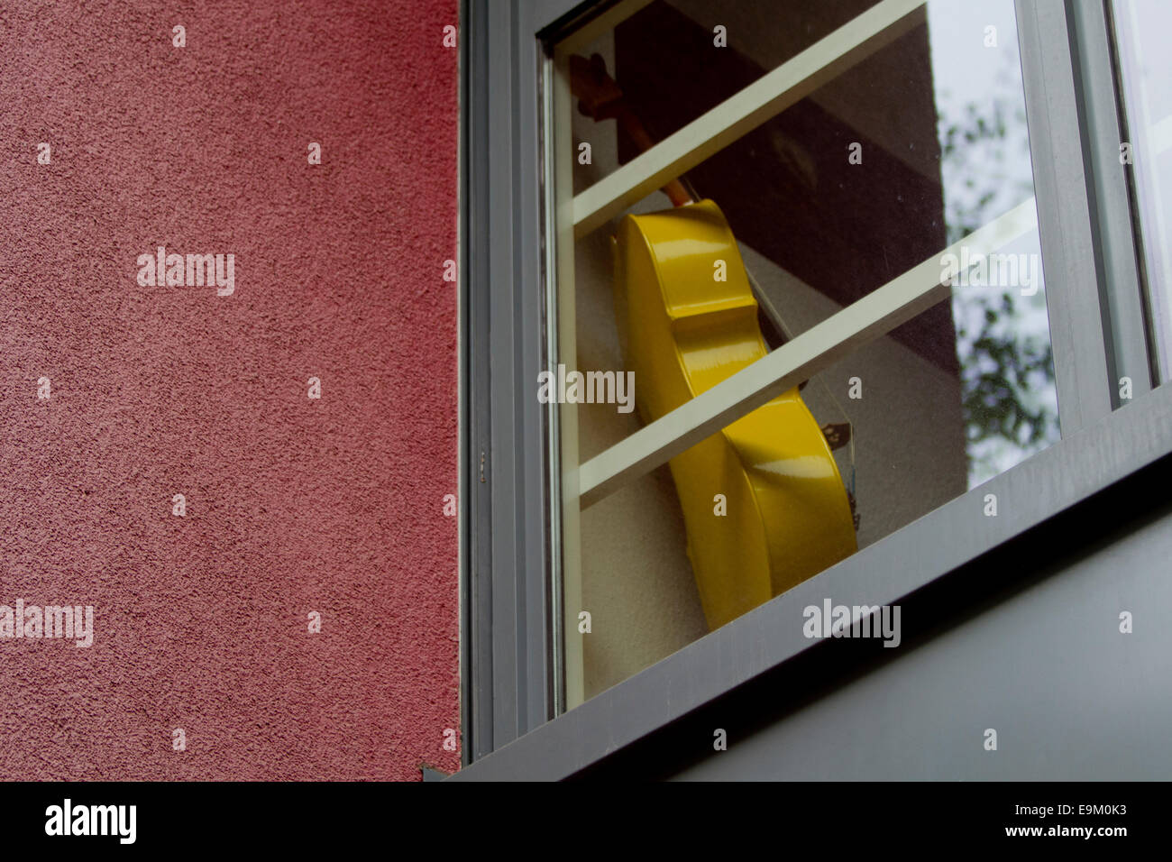 Yellow Cello in window cool Berlin Stock Photo