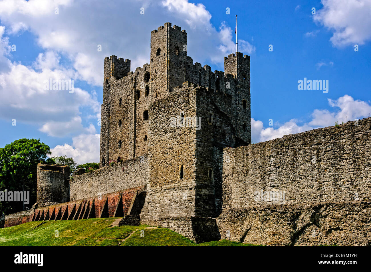 The dominant Kentish ragstone keep of Rochester castle protected by a curtain wall, a rectangular tower and a circular tower. Stock Photo