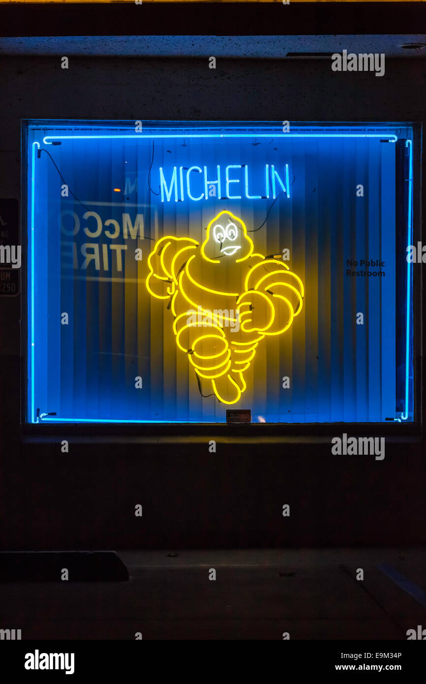 McCoy Tire dealer in Modesto California USA with a neon running Michelin Man Bibendum in the front window Stock Photo