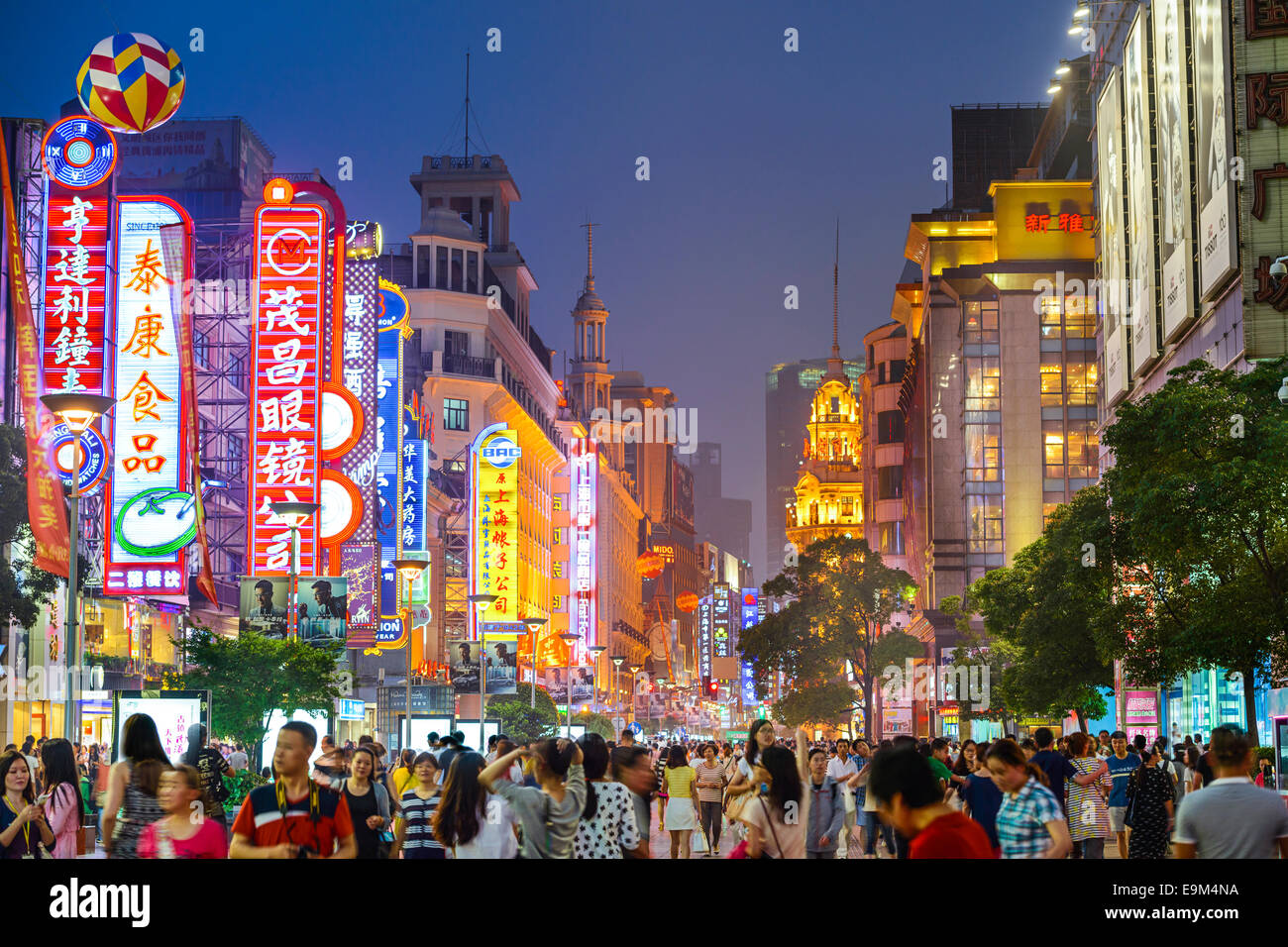 SHANGHAI, CHINA - JUNE 16, 2014: Neon signs lit on Nanjing Road. The street is the main shopping road of the city. Stock Photo