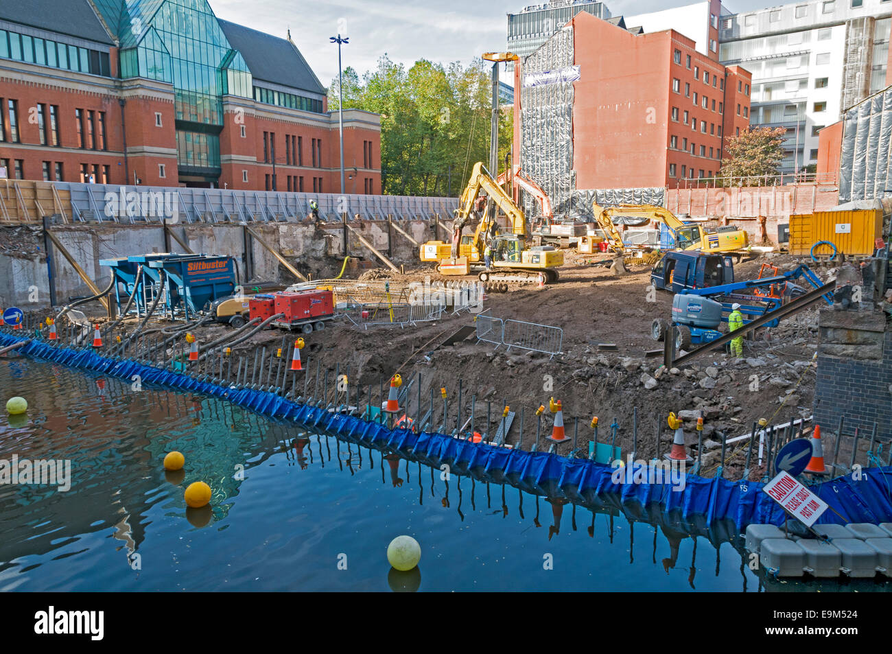 Construction site for a Holiday Inn alongside the Rochdale Canal, Manchester, England, UK, with a temporary dam for the canal. Stock Photo