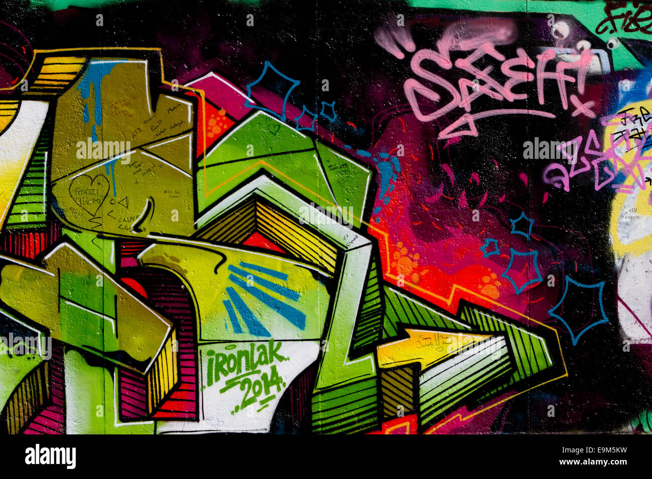 Graffiti street art Berlin Wall urban tags colour Stock Photo