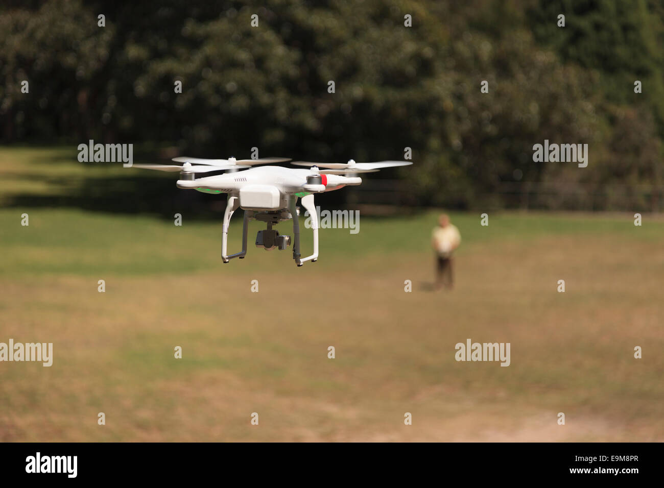 Drone Photographer with flying Drone in full view. The male Photographer is out of focus the drone sharp. Stock Photo
