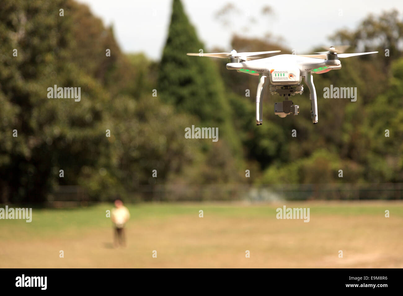 Drone Photographer with flying Drone in full view. The male Photographer is out of focus the drone sharp. Stock Photo