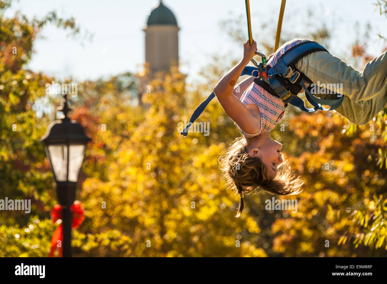 Child doing somersaults while bouncing on a bungee jump at the Snellville Fall Festival near Atlanta, Georgia, USA. Stock Photo