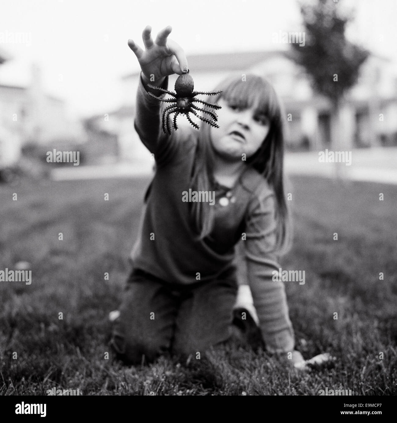 A girl holding a fake spider Stock Photo