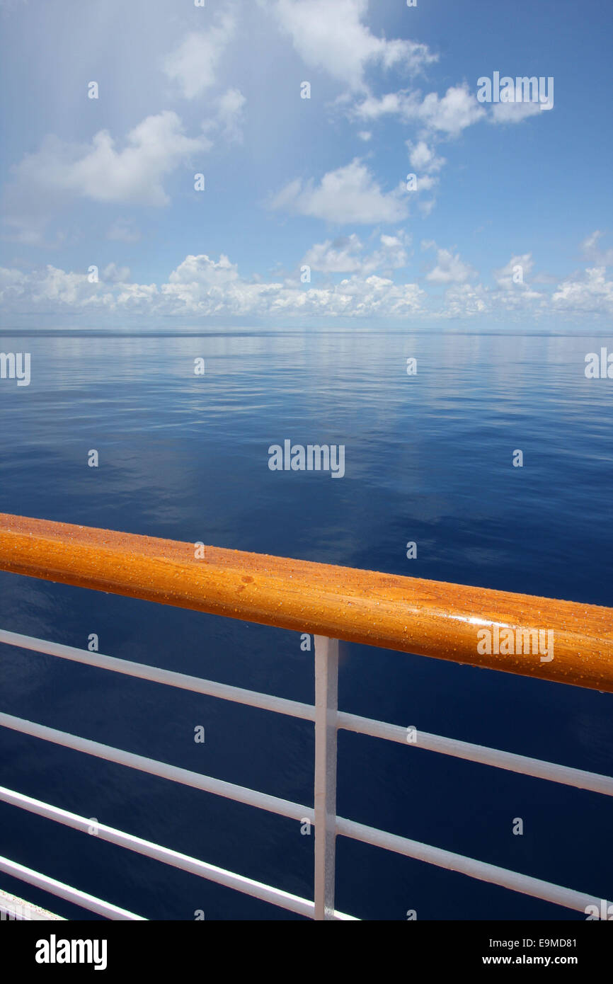 View of a calm still ocean on a beautiful sunny day, with the hand rail of a cruise ship in the foreground, Indian Ocean. Stock Photo