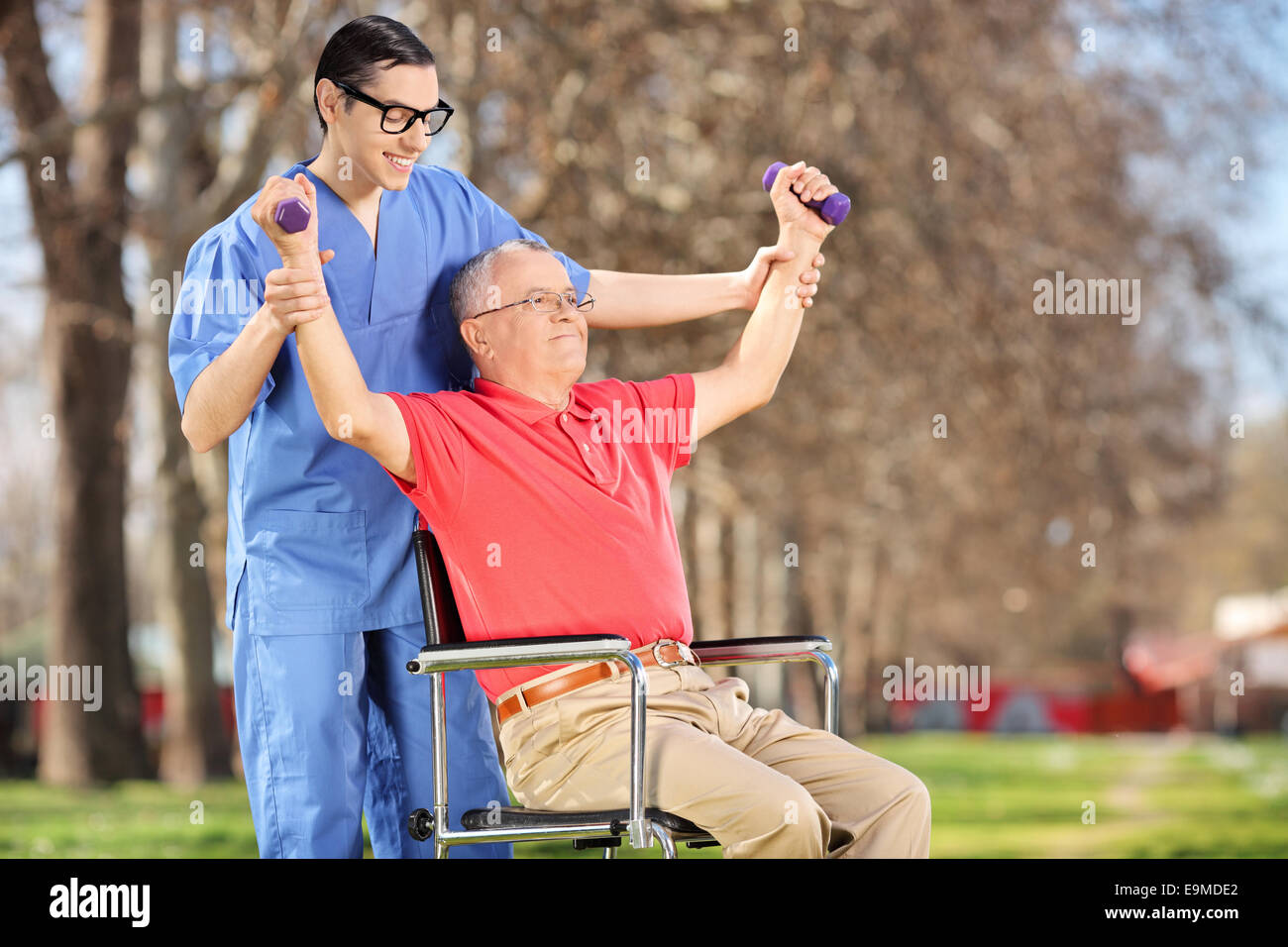 Physiotherapist exercising with a mature patient in park Stock Photo