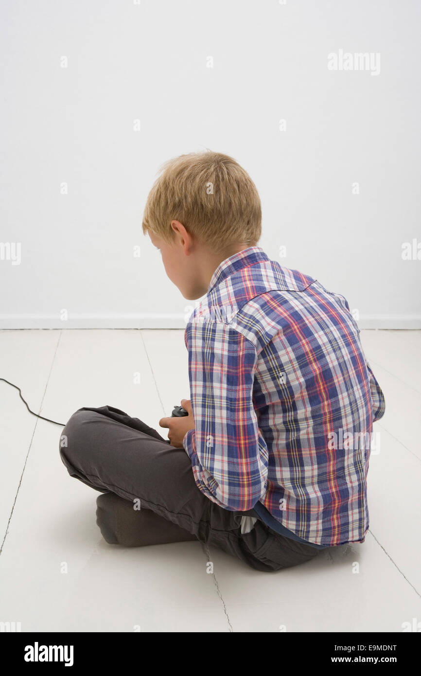 Rear view of boy playing video game Stock Photo - Alamy