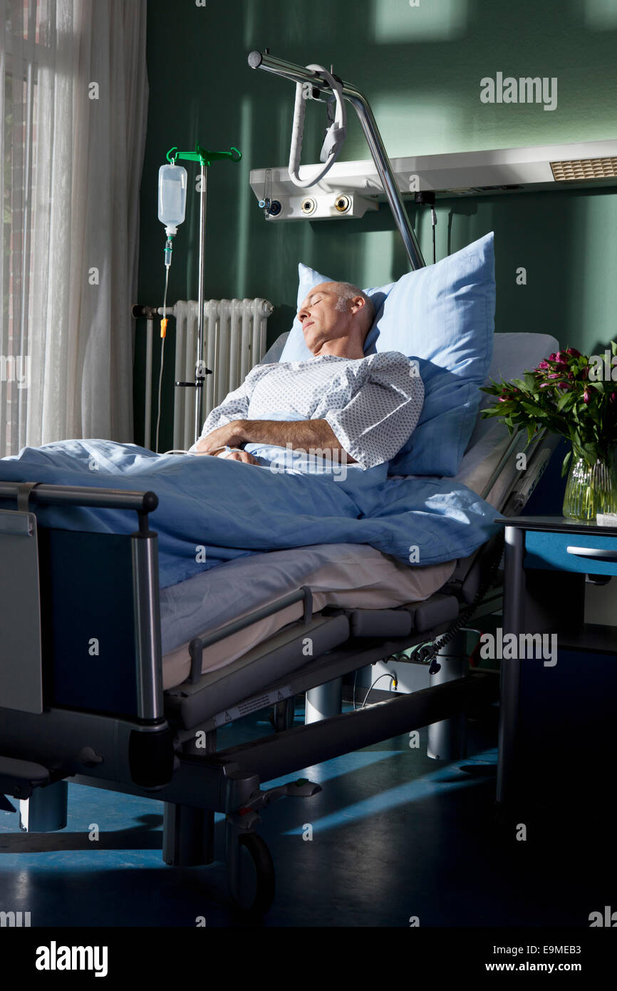 A man sleeping in a hospital bed Stock Photo - Alamy