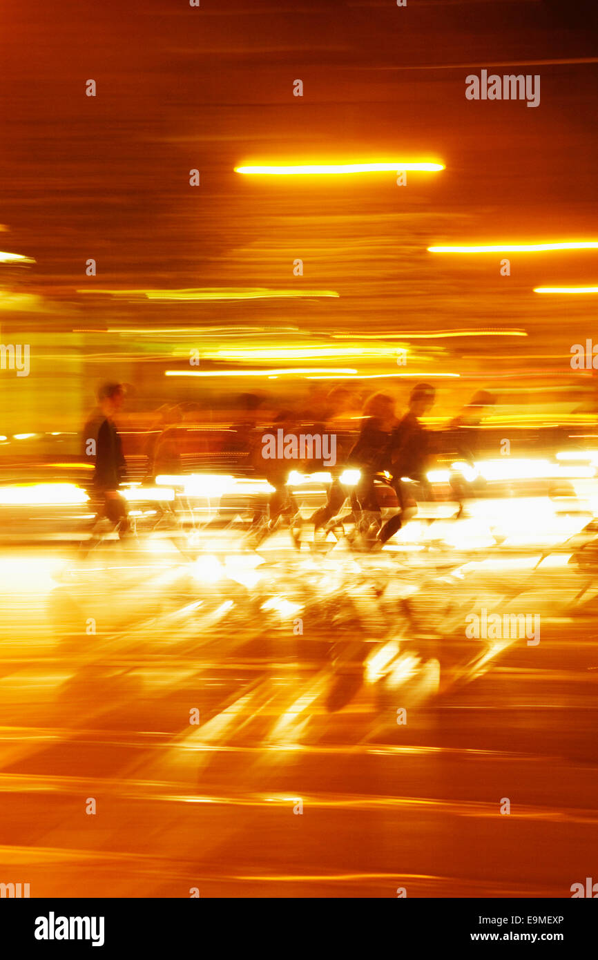 Blurred motion of people walking in illuminated tunnel Stock Photo