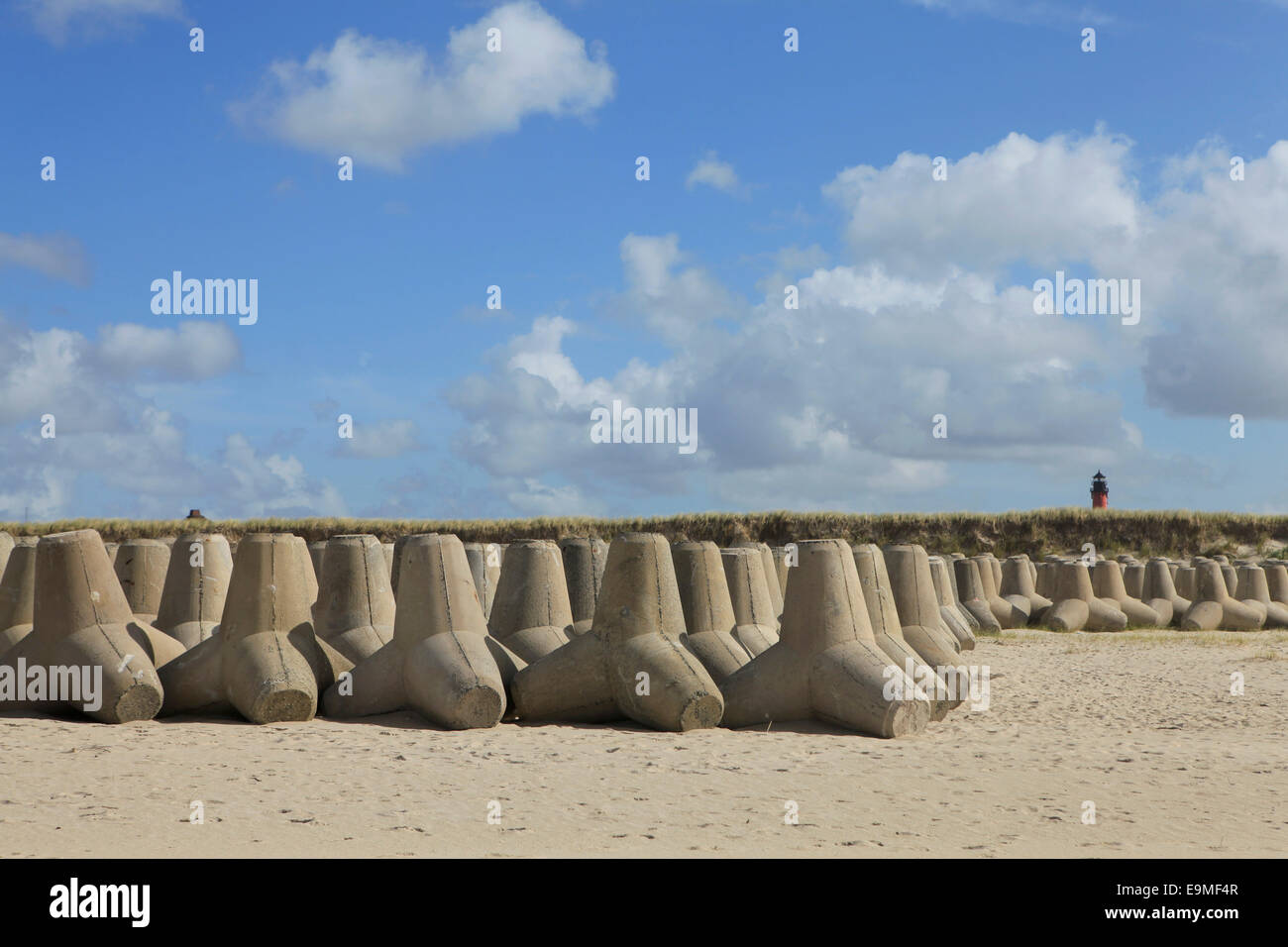Tetrapod rocks arranged on sandy beach against sky Stock Photo