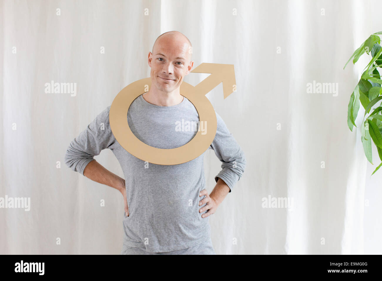 Portrait of smiling man wearing male symbol in neck at home Stock Photo