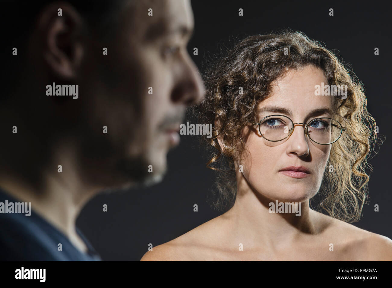 Angry woman looking at man in foreground Stock Photo