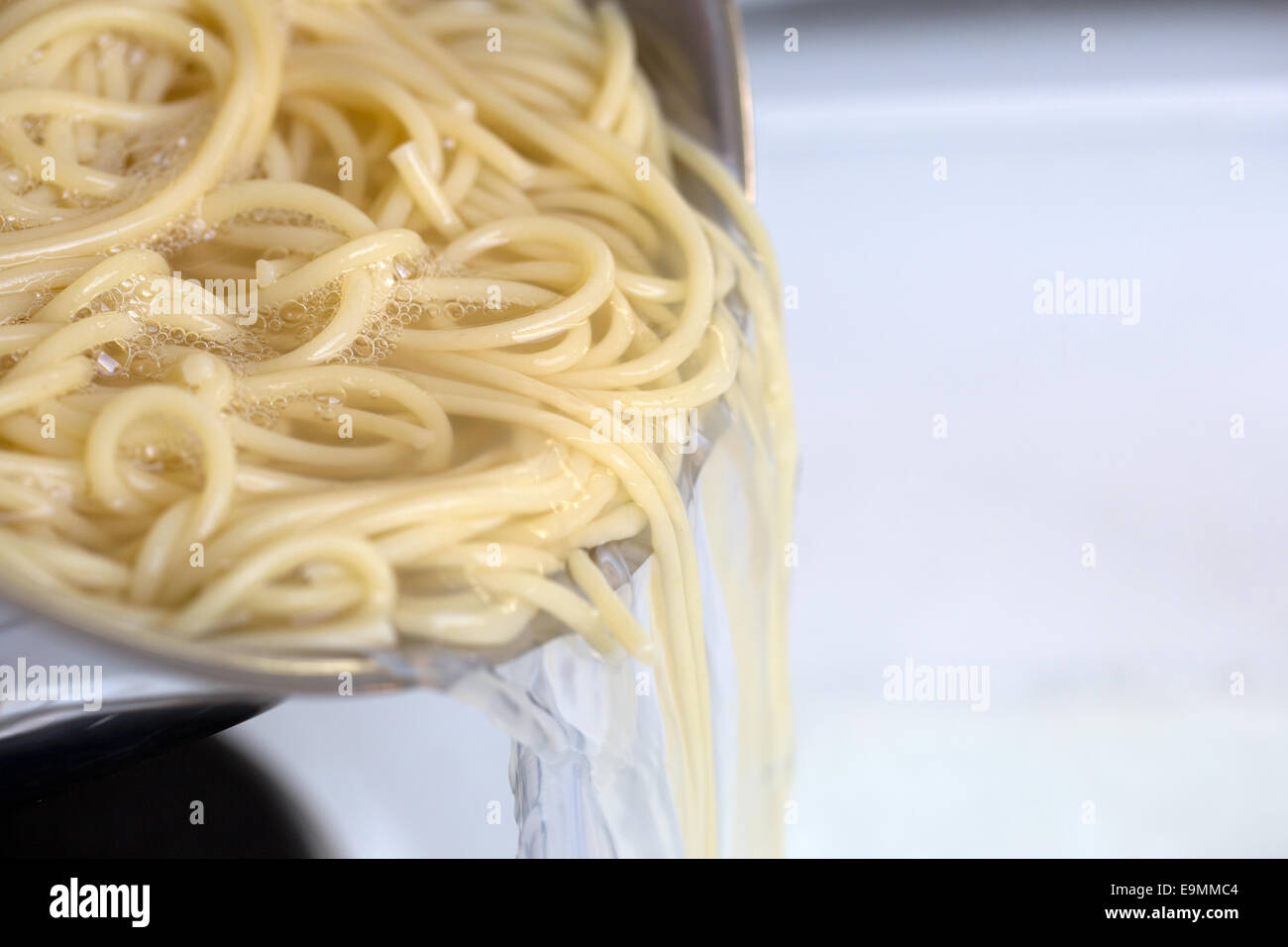 Cooking spaghetti noodles meal: strain the pasta from hot water Stock Photo