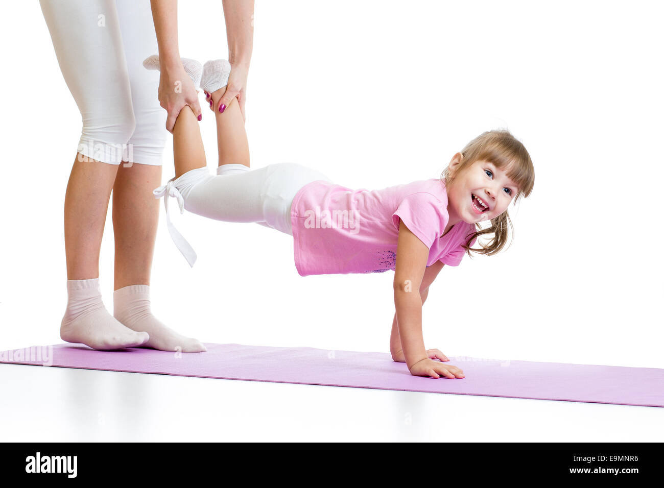 kid girl doing gymnastic and standing on her hands Stock Photo