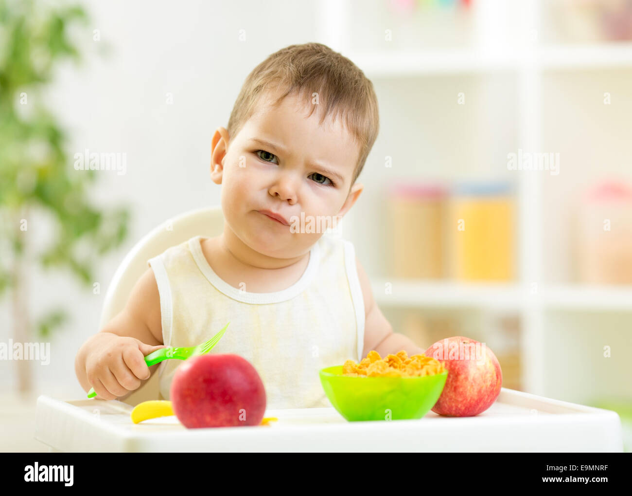 displeased kid boy with healthy food at kitchen Stock Photo